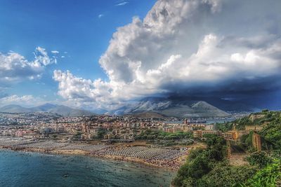 View of cityscape against cloudy sky