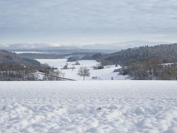 Snow covered field against sky
