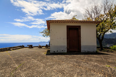 Exterior of building by sea against sky