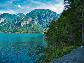 Scenic view of lake by mountains against sky