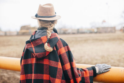 Real view of woman standing by railing on field