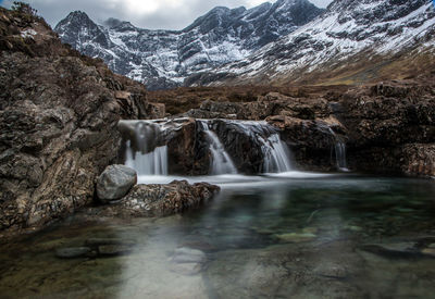 Scenic view of waterfall against sky during winter