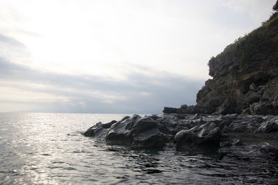 Scenic view of rocks in sea against sky