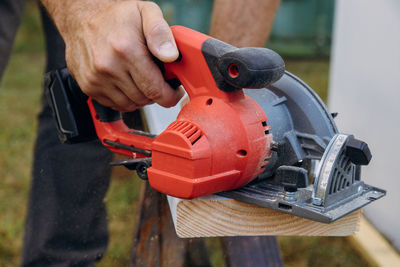 Midsection of man repairing wood