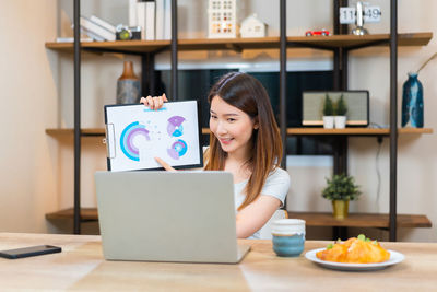 Portrait of woman using laptop at table
