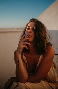 Portrait of a young woman sitting outdoors