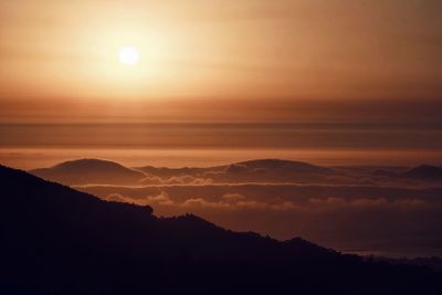 Scenic view of silhouette mountains against romantic sky at sunset