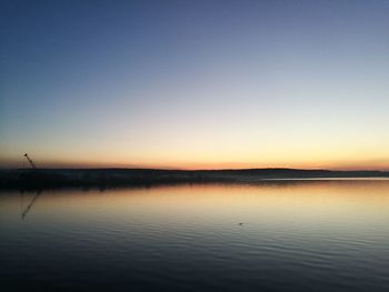 Scenic view of lake against clear sky during sunset