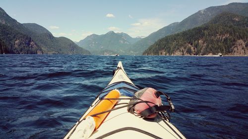 Cropped image of kayak in sea against mountains