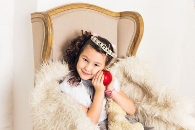 Portrait of smiling girl lying on wall