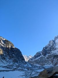 Scenic view of snowcapped mountains against clear blue sky