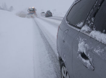 Snow covered car on road