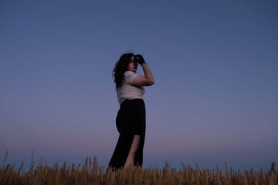 Rear view of woman standing against clear sky