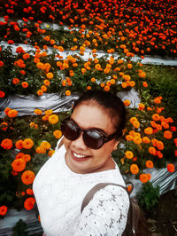 Portrait of smiling woman with red flowers