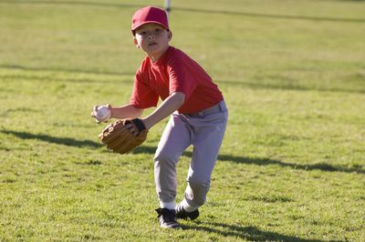 Young boy fielding a baseball during tball game