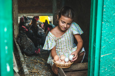 Cute girl holding eggs in basket