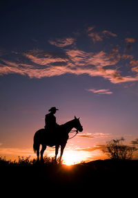 Low angle view of silhouette man on horse against sky during sunset