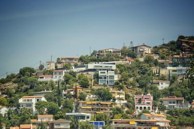 Houses in town against clear blue sky