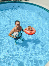 High angle view of father with daughter in swimming pool