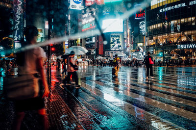 Illuminated wet street during rainy season at night