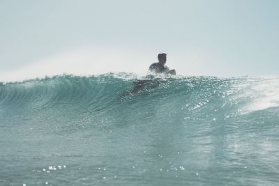 Man surfing in wave in sea