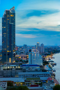 Illuminated buildings in city against sky