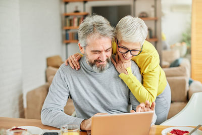 Man and woman using laptop at home