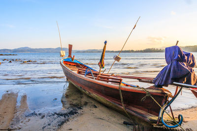 Boats moored on shore against sky