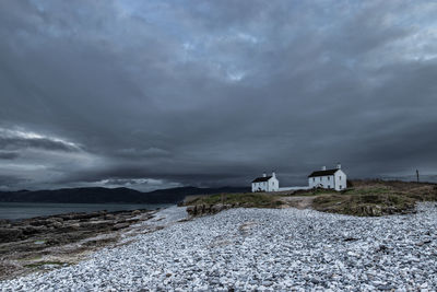 Cloudy sky at sunset over the two cottages at penmon point near the lighthouse 