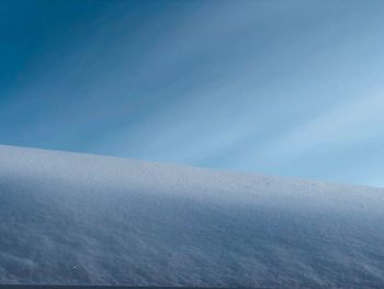 Scenic view of snowcapped mountains against blue sky