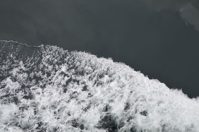 Close-up of sea shore against mountain