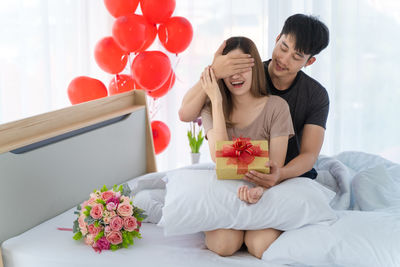 Young couple kissing against white wall