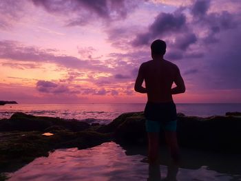 Rear view of man standing on beach