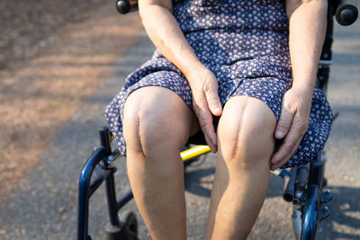 Low section of woman riding bicycle on street