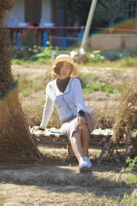 Full length of woman sitting on sunny day