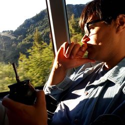 Portrait of man holding camera while sitting in car