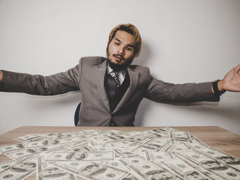 Young businessman with paper currency at table