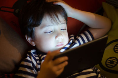 Close-up of boy using mobile phone at home
