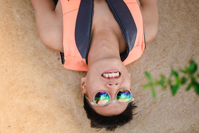 Portrait of smiling man in sunglasses lying down at beach