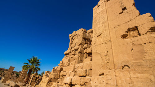 Low angle view of old ruins against clear blue sky