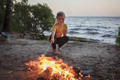 Full length of smiling young woman on land against sky