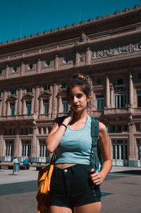 Young woman standing against building in city