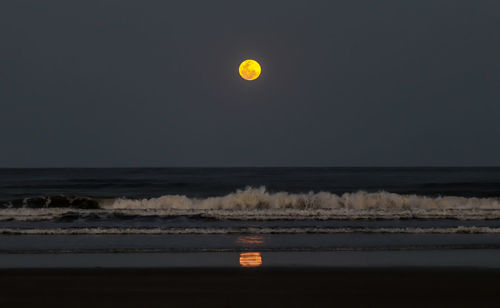 Scenic view of sea against clear sky at night