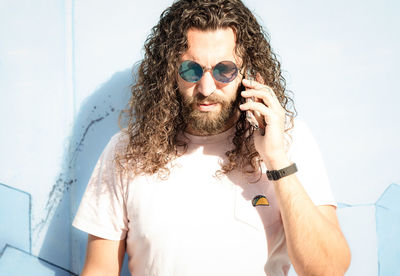 Portrait of young man on the phone against white background