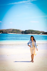 Full length of young woman standing on beach