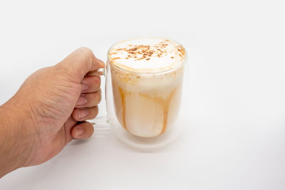 Midsection of coffee cup against white background