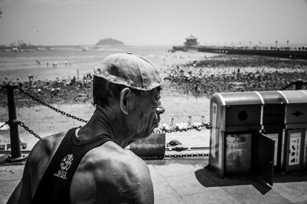 sea, water, sky, focus on foreground, rear view, clear sky, beach, men, one animal, leisure activity, part of, sitting, lifestyles, domestic animals, horizon over water, close-up, outdoors, day