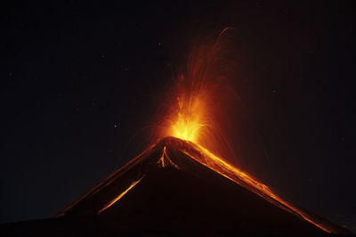 Volcano eruption in the dark with stars sky on the background