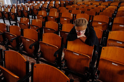 Woman sitting on chair at auditorium