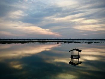 Scenic view of lake against sky at sunset